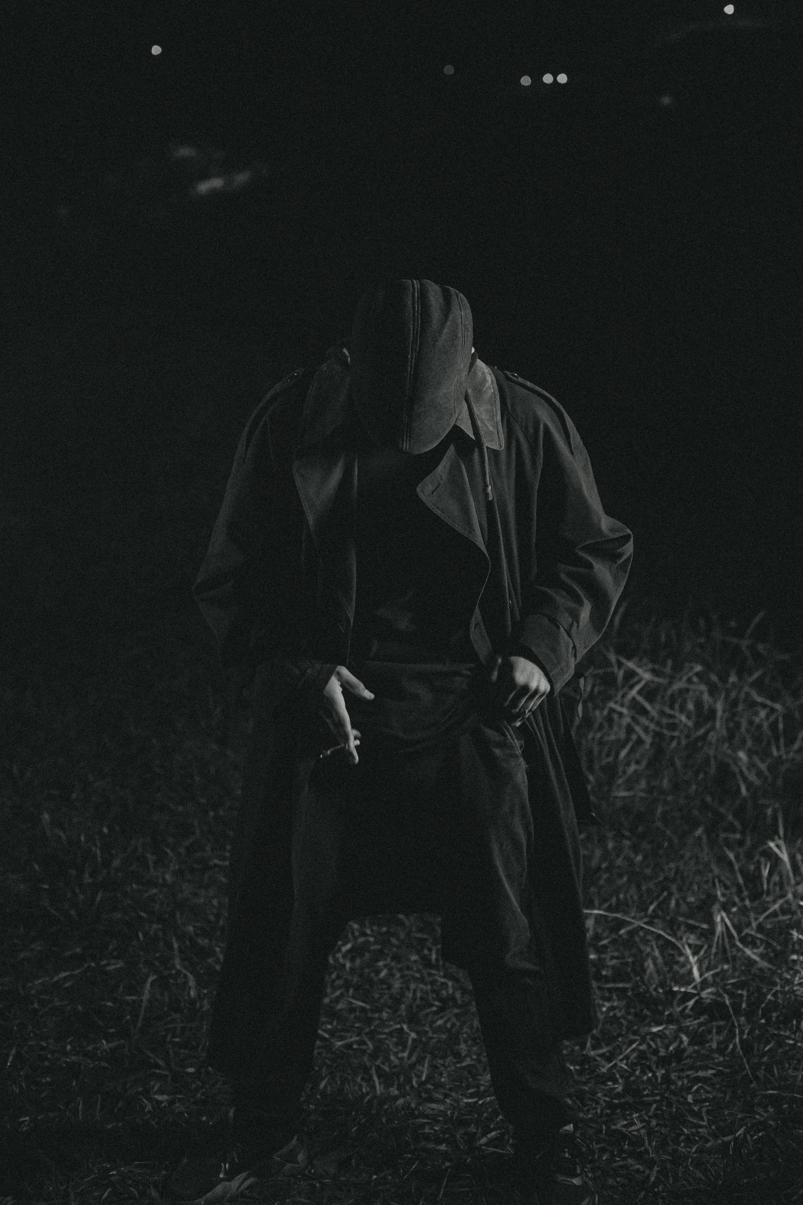 man sitting on a bench with his eyes closed at night