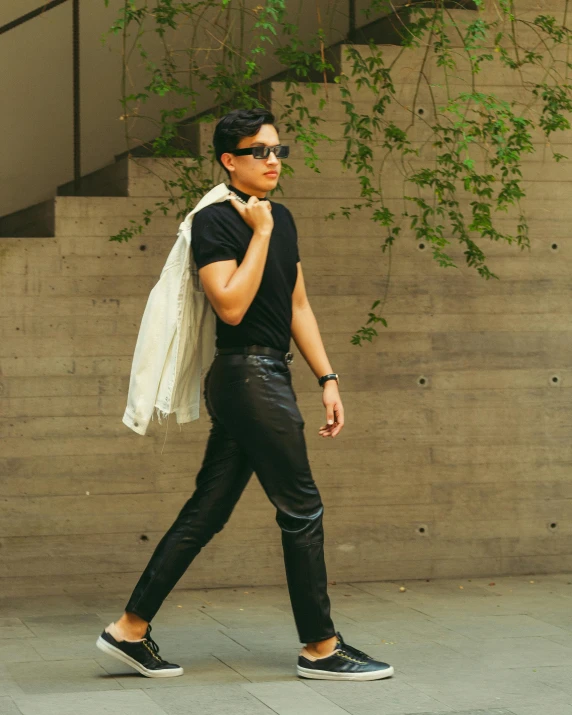 man in black and white sneakers walking down a sidewalk