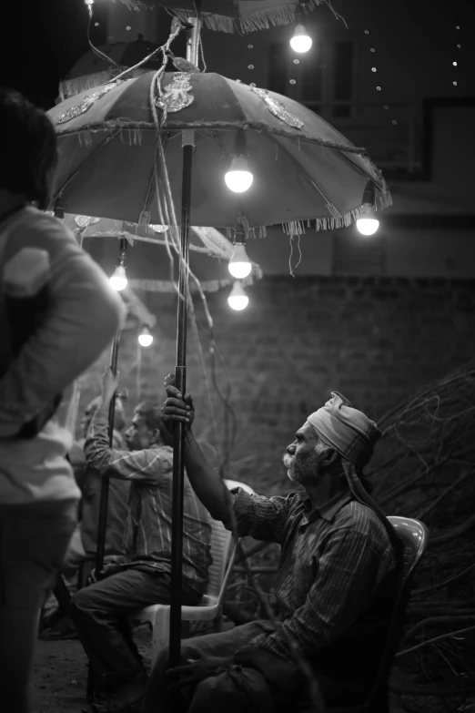 a man sitting on a chair in front of an umbrella