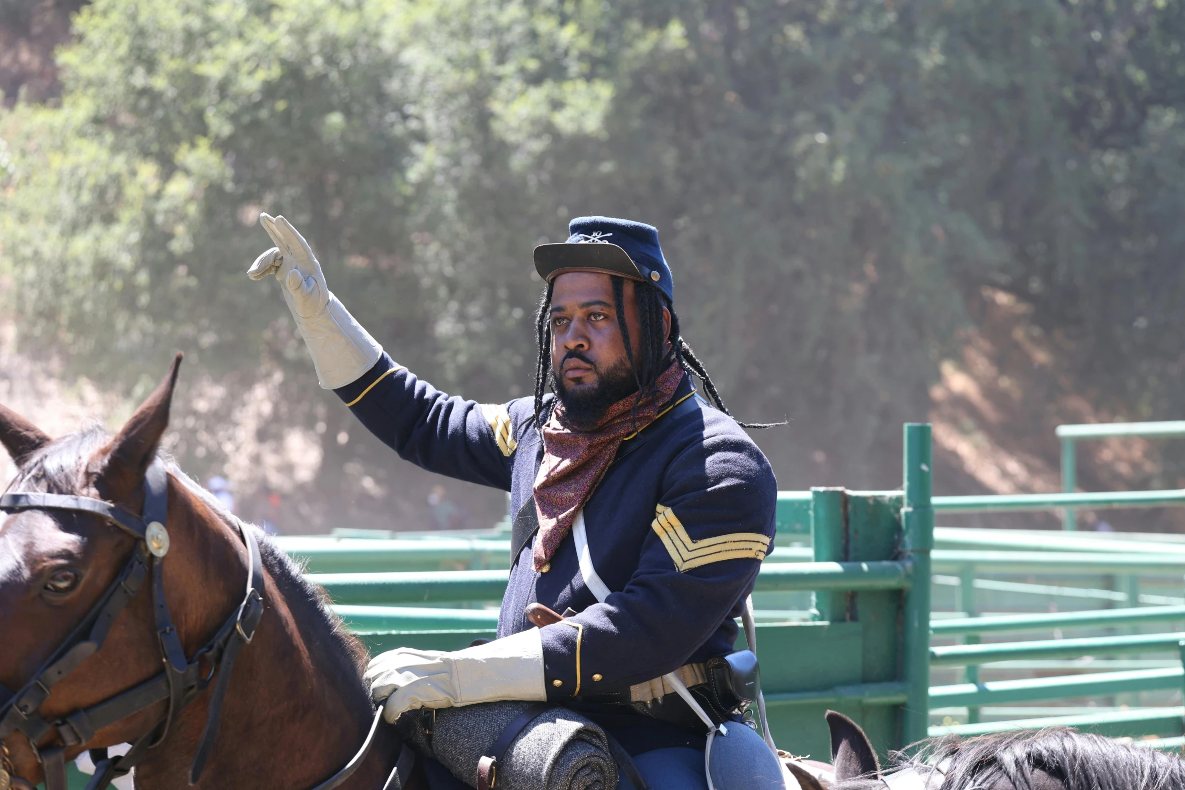 a man wearing a blue jacket sitting on top of a horse