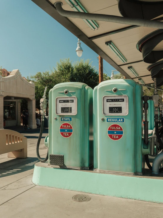 two old gas pumps lined up on a concrete platform