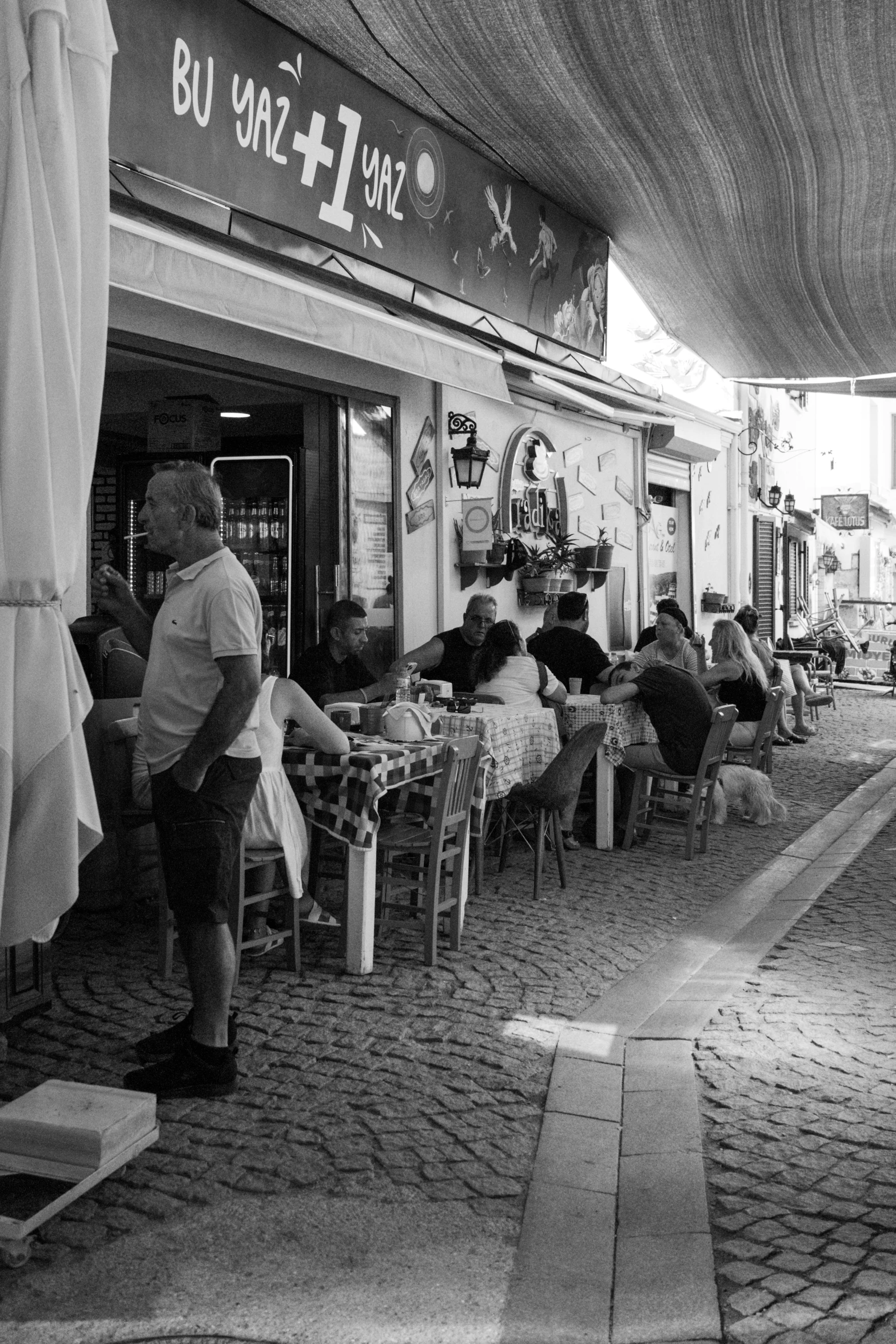 many people eating outdoors under a covered area