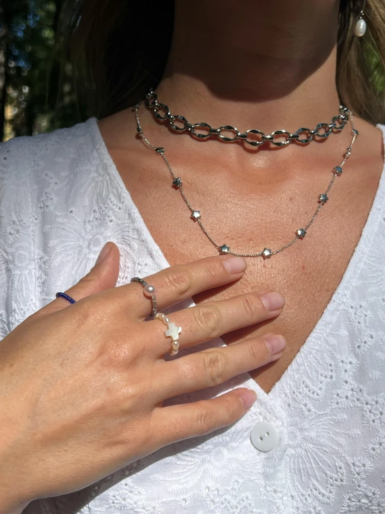 woman wearing a silver necklace and white shirt