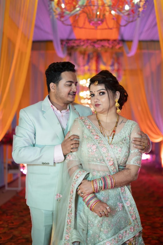 two people dressed in wedding attire standing together