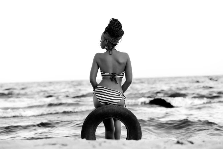 a woman in a bathing suit standing on top of an inner tube