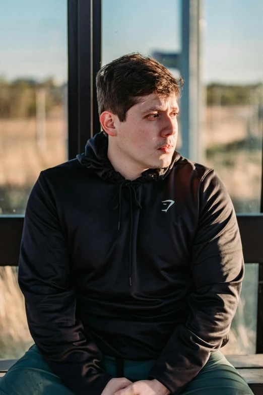 a man in black shirt sitting on top of a bench