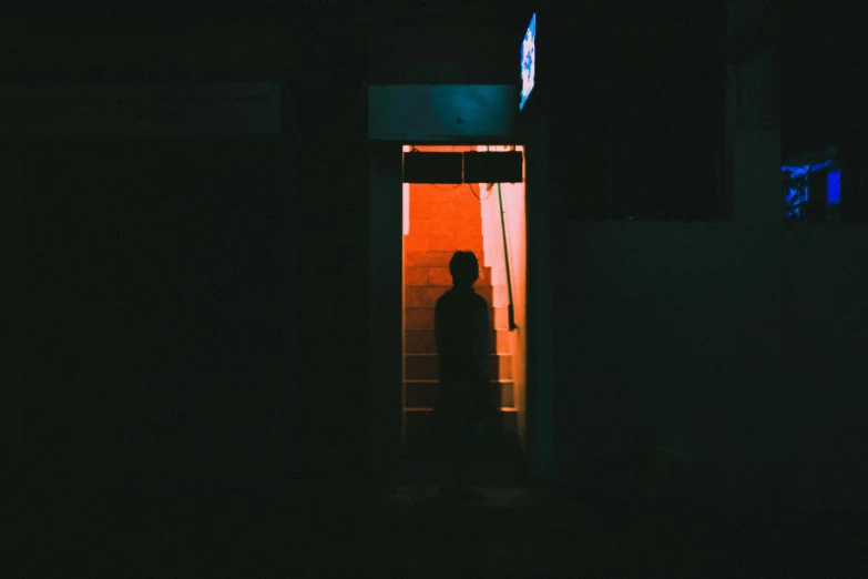 a man in a dark doorway at night