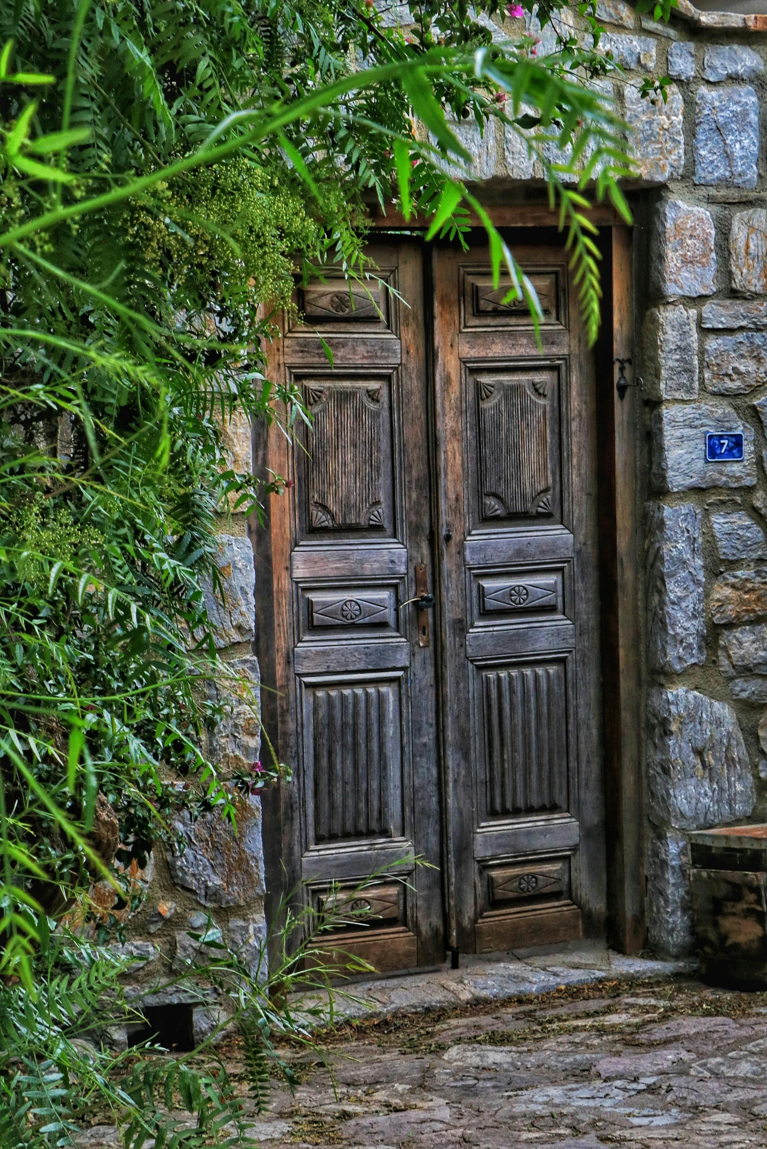 a doorway is made of wood and is surrounded by vegetation