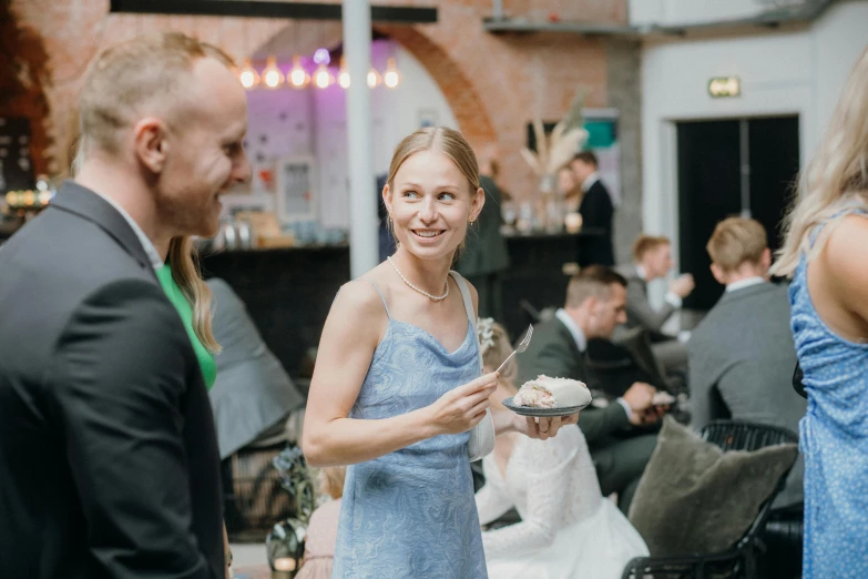 a woman in a strapless dress holds up a dessert