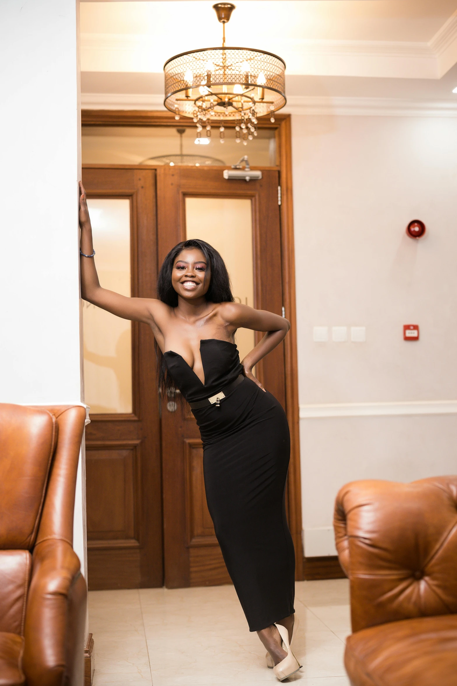 a woman posing in an elegant dress by a door