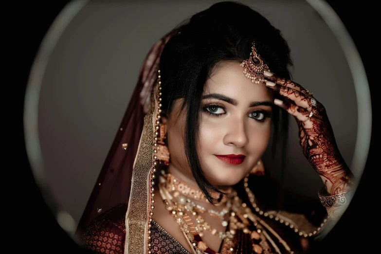 a bride holding her veil while looking at the camera