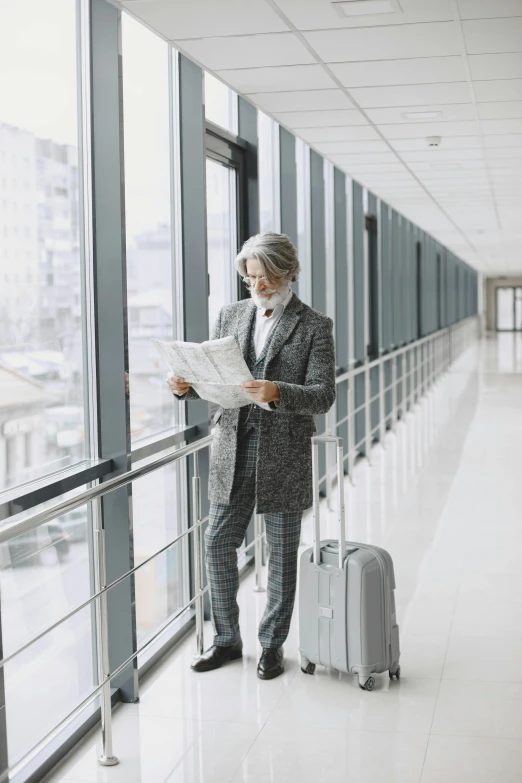 man in business attire looking at his plan and luggage