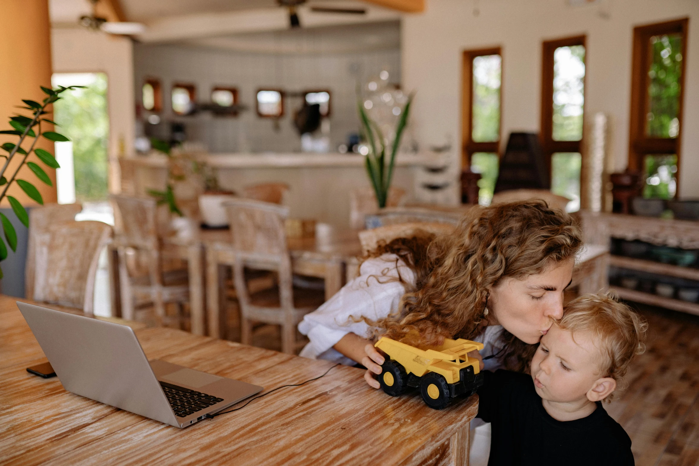 a woman and her son playing with a small truck