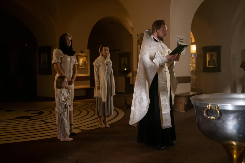 a priest standing in front of a crowd of people