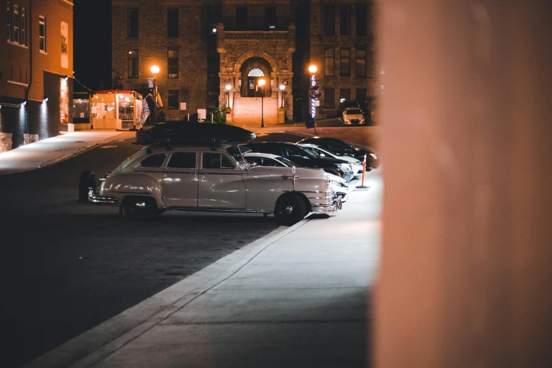 cars parked in front of a building at night