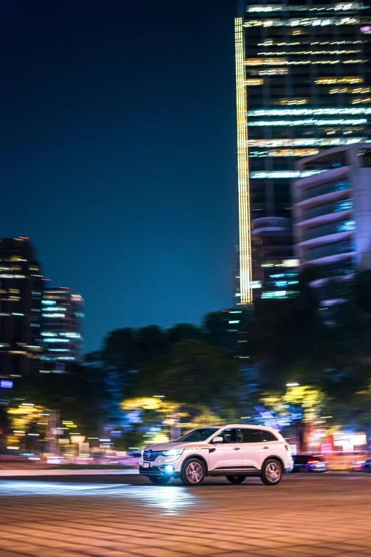 a city at night with some cars driving through the city