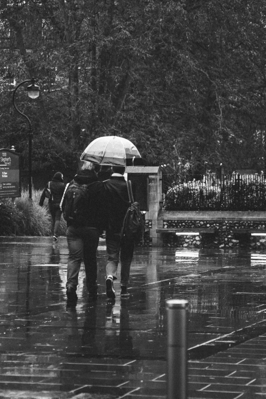 two people walking under an umbrella in the rain