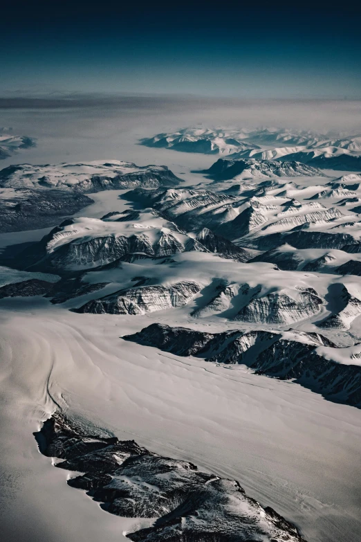 the view from a plane shows snow covered mountains and valleys