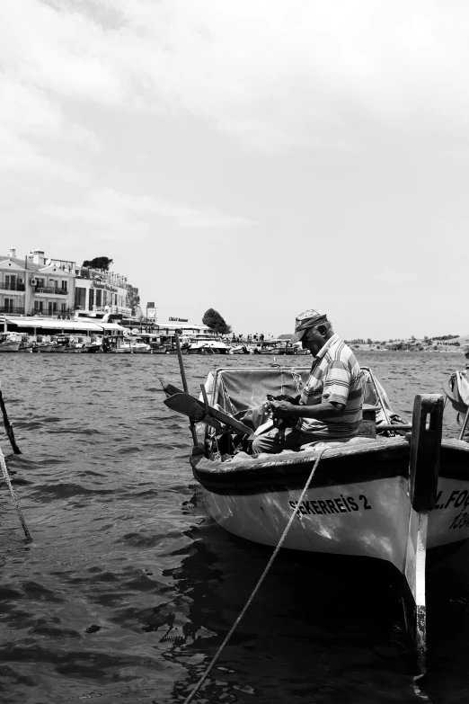 a man on a boat in the water near another man