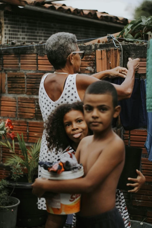 a woman holding a boy and a little boy