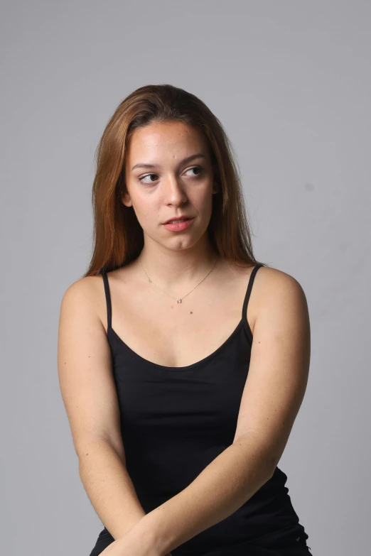 a woman is sitting down with her hand on her chest