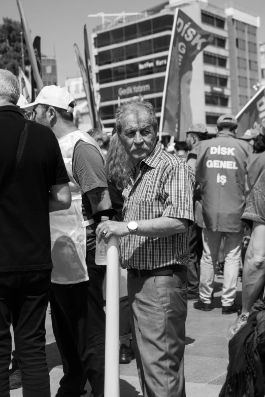 a man standing holding a large baseball bat in the middle of a crowd