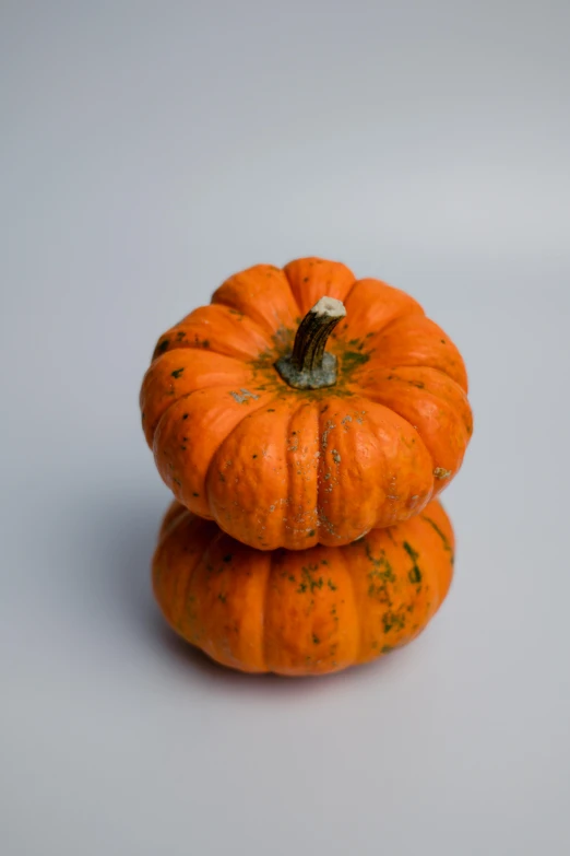 three pumpkins stacked up in a pile