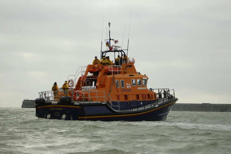 an orange tugboat with several men on board