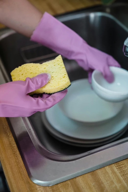 someone cleaning a kitchen sink with a sponge