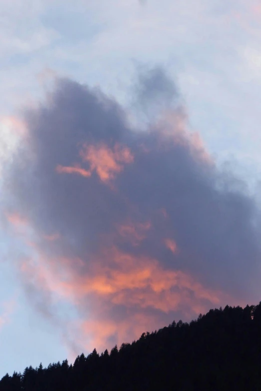 some clouds are in the sky above some trees