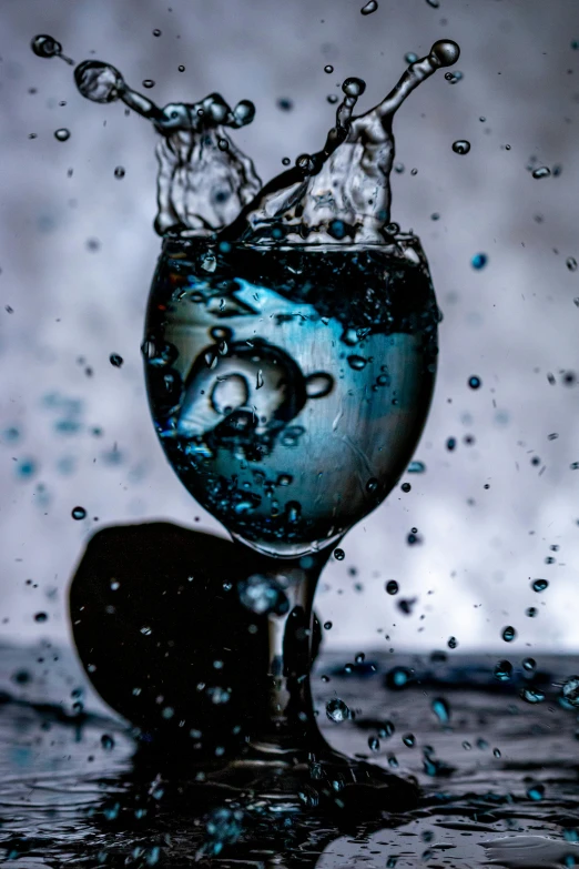 a glass full with liquid and some water droplets