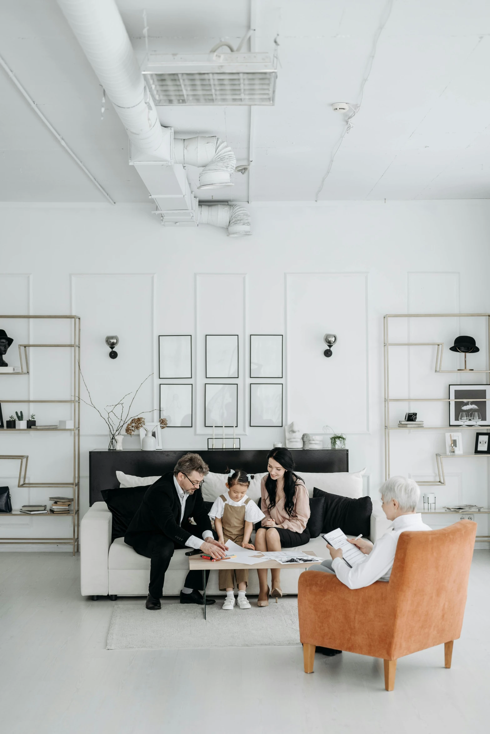 three people sitting in a couch in an office