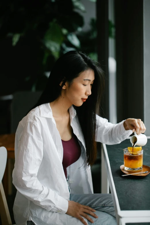 woman at a table with a jar of honey on her lap