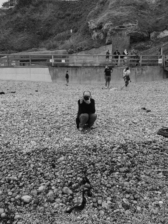 some people are standing near the lake while a man stands behind