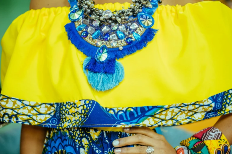 an african fashion show wearing a yellow top with blue jewelry