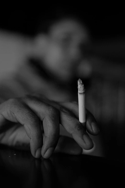 a close up of a person holding a cigarette