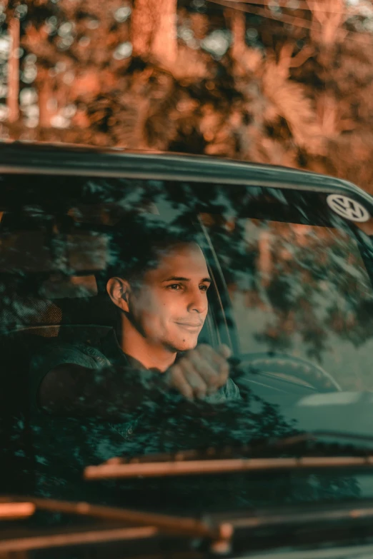 a man in his car is smiling and showing the thumbs up