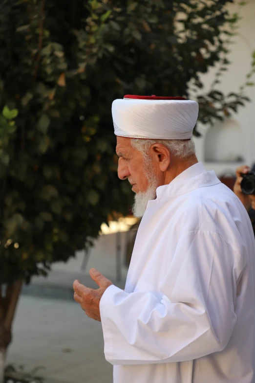 an older man with white hair and a red cap