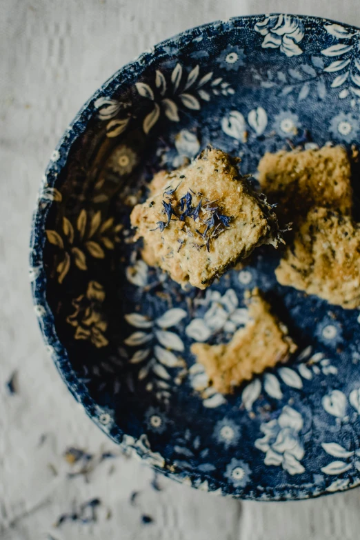 a blue plate topped with three cookies and a bite taken out