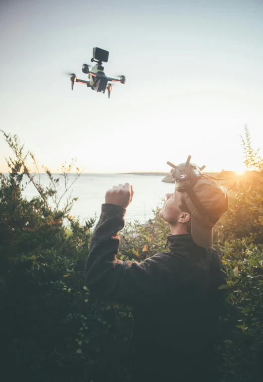 man with flying camera taking picture of a lake