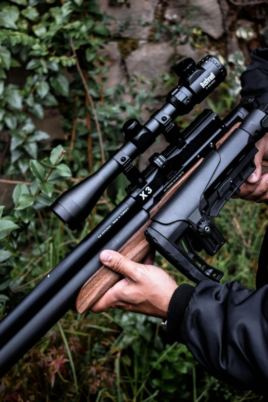 a man is holding a rifle on a tripod