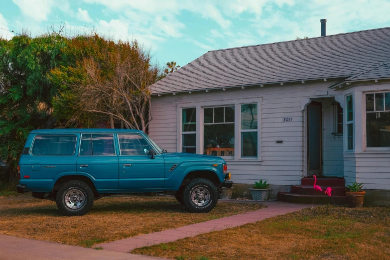 a blue truck parked in front of a house