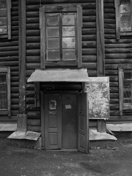 black and white pograph of a door in front of a log house