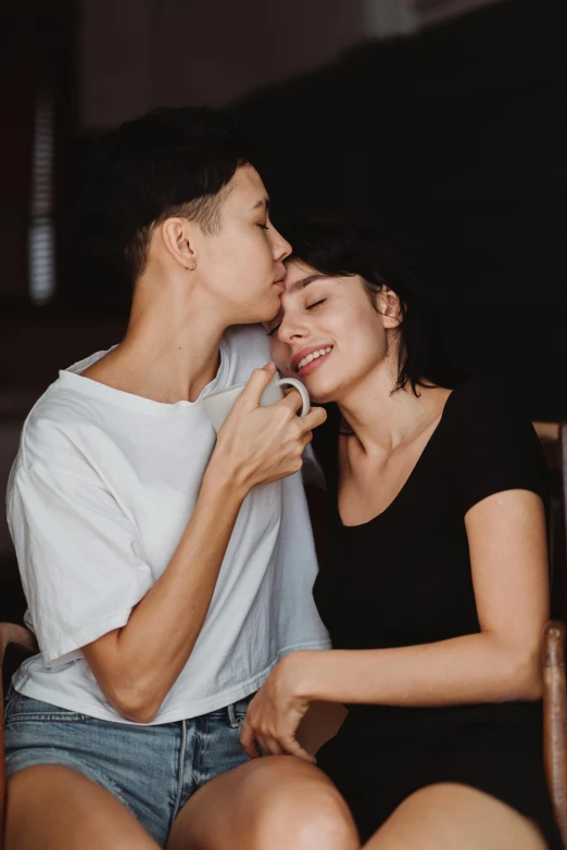 a man and a woman cuddling and kissing on the foreheads