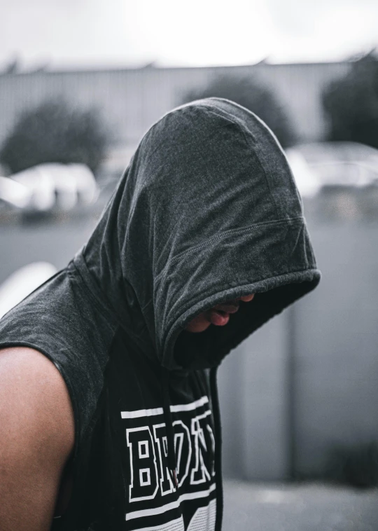 a person is wearing a hoodie and looking down