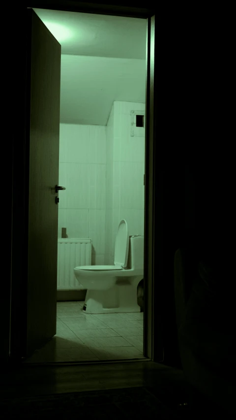 a small bathroom with an open doorway to a toilet