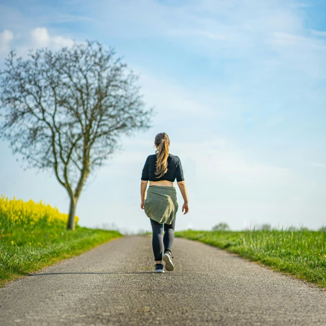 a person walks down the middle of the road on a skateboard