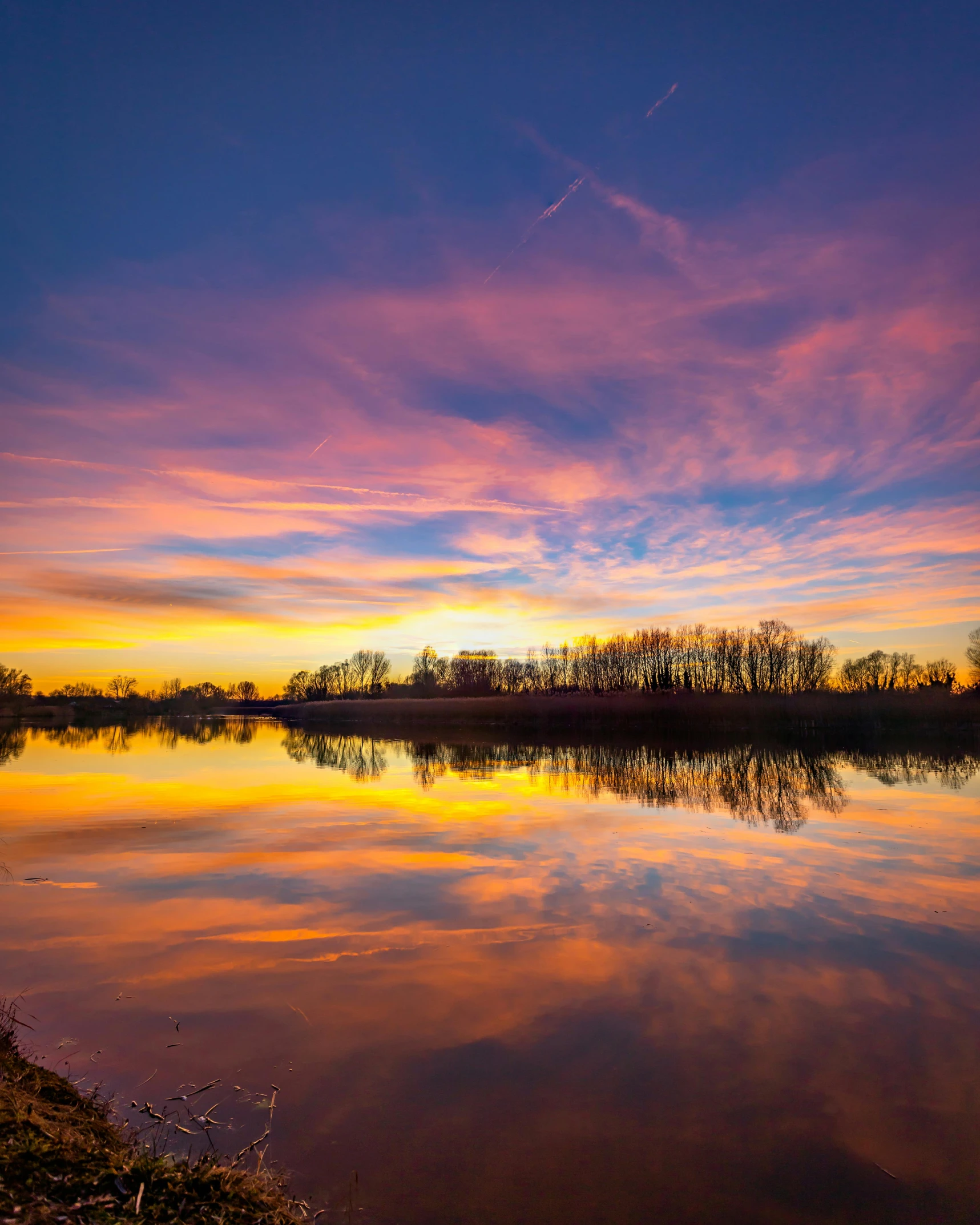 a colorful sunset reflects the sky on water