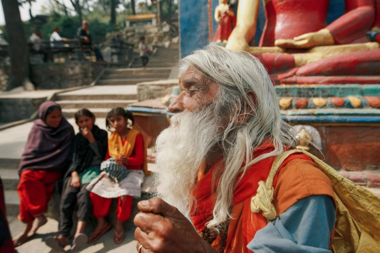 people are standing near one another in front of buddha statues