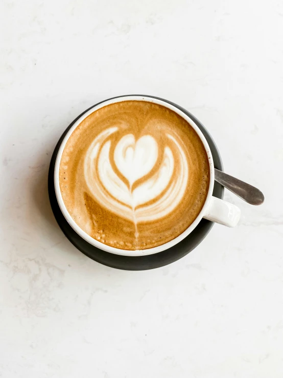 latte art drawn with the shape of a heart in a cup